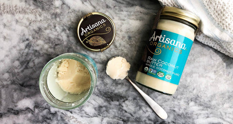 A jar of coconut butter with a nice scoop taken out showing a delicious texture.