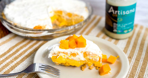 A slice of No Bake Mango Cream pie on plate topped with pieces of mango.