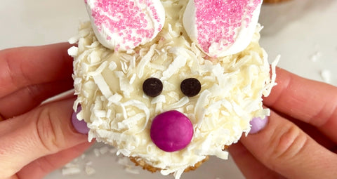 A vanilla coconut cupcake decorated like a cute bunny