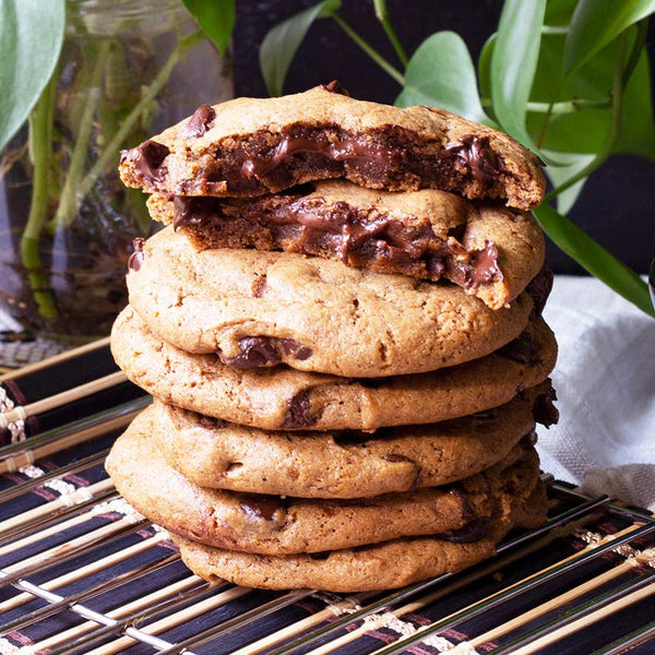 Hazelnut stuffed chocolate cookies stacked with the top cookie broken in half showing a delicious cross section. 