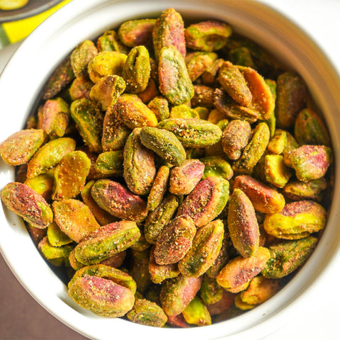 Pistachios in a white bowl with a blurred background