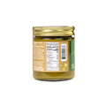 A glass jar of olive oil with a gold metal lid, showing the back label with nutrition facts and barcode on a white background.