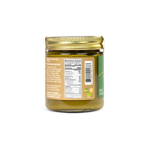 A glass jar of olive oil with a gold metal lid, showing the back label with nutrition facts and barcode on a white background.