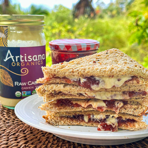 A stack of cashini and jelly sandwiches on a plate.